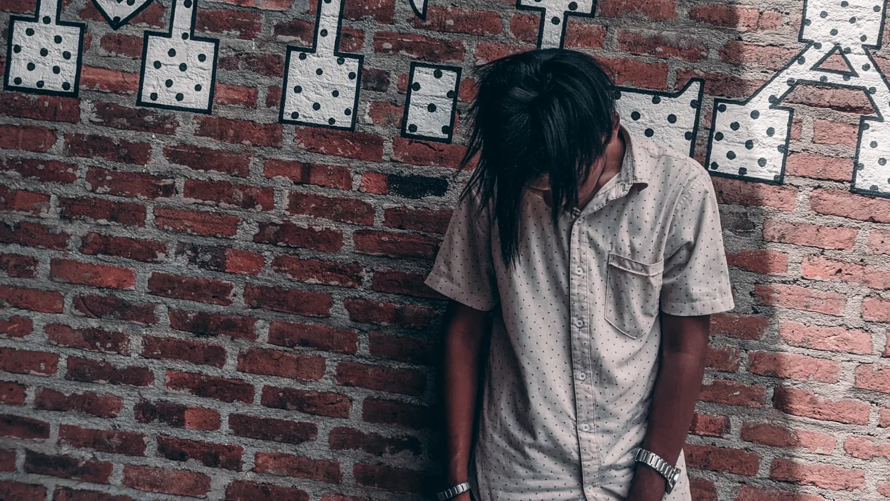 Sayuru Akash Amarasinghe photographed against a painted brick wall